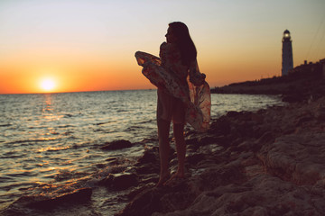 Woman at sunset by the sea. Beautiful woman. 