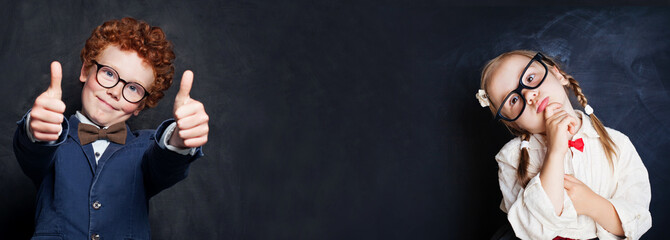 Mischievous kids boy and girl on blackboard background with copy space