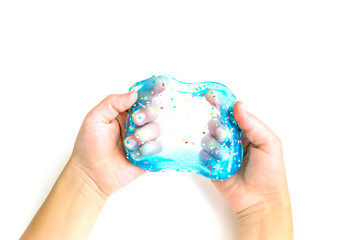 Modern toy called slime. Child playing transparent blue slime. Hands holding a mucus isolated on a white background. Selective focus.