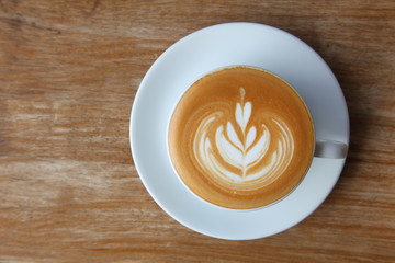 Top view of coffee latte art with tulip pattern on top on rustic wooden table bar with copy space