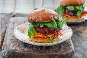 Vegetarian beetroot burger with avocado and carrot slaw in brioche bun