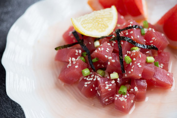 Close-up of tuna ceviche with grapefruit juice, green onion, nori and sesame seeds, selective focus