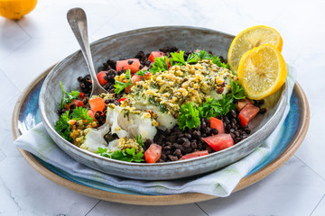 Pesto-crusted cod with Puy lentils and tomatoes in a bowl