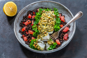 Pesto-crusted cod with Puy lentils and tomatoes in a bowl