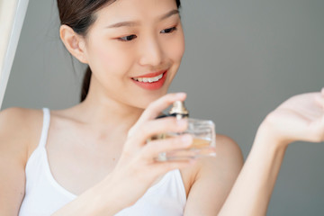 attractive asian beautiful teen woman enjoy new perfume at her wrist home background