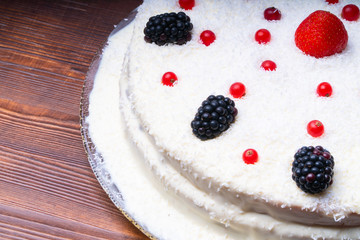 homemade cake, blackberries red currants raspberries on a wooden table. rustic