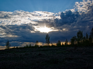 Fototapeta na wymiar bright sunset in spring through the clouds, Russia.