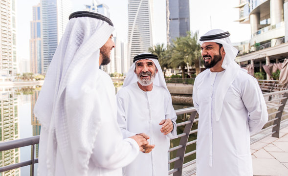 Businessmen in Dubai speaking about business. Local people with traditional clothes