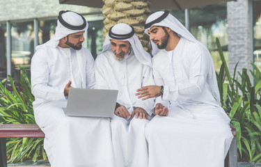 Businessmen in Dubai speaking about business. Local people with traditional clothes