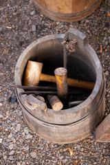 Medieval smith tools in a wooden bucket, hammers forceps and some more