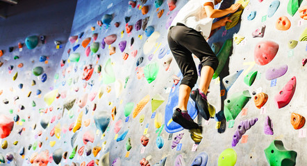 [ボルダリング] ボルダリングスタジオで壁に登る前に滑止めをつけて気合いを入れる女子小学生クライマー