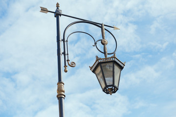 Fototapeta na wymiar Old lamp on the blue cloudy sky