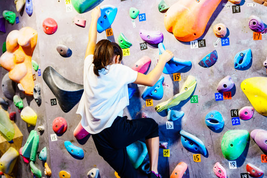 [ボルダリング] ボルダリングスタジオで壁に登る前に滑止めをつけて気合いを入れる女子小学生クライマー