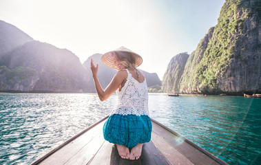 Young woman making a tour on the long tail boat, going to phi phi island