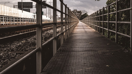 Walkway next Railroad and beautiful sky at sunset in summer. Rural industrial landscape with railway station