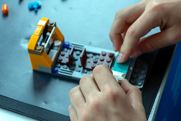 Junge konstruiert mit Bausteinen aus Plastik kreative Spielwelten und trainiert seine räumliche Vorstellungskraft mit 3D Modellen und hat Spaß dabei