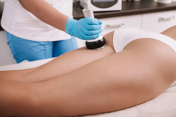 Cropped shot of a woman getting rf-lifting treatment on the back of her legs by professional...
