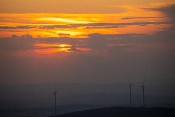 Wind turbines in the front of a red sunset