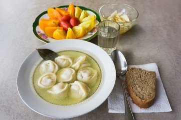 Dumplings, tomatoes, radish, bread and a glass of vodka