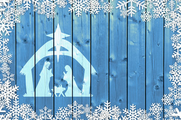 Blue Christmas winter background with Nativity Scene and snowflakes on wood