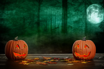  two halloween pumpkins with autumn leaves