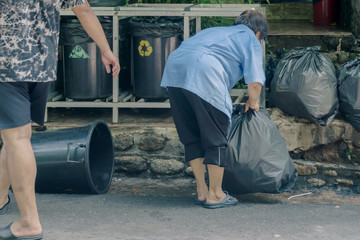 Female worker sort the garbage and packed in black bags for transportation convenience.