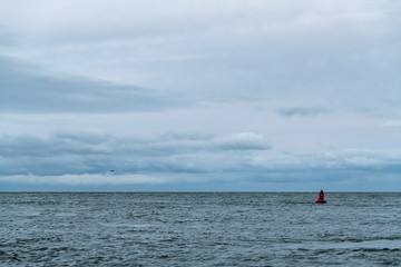 A red marker bouy in the River Exe estuary marking the channel around Dawlish warren sand spit, off Exmouth in Devon, England.