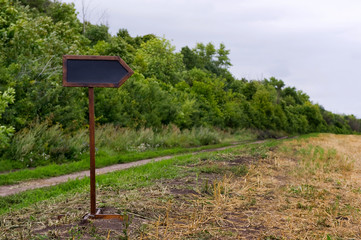 blank wooden direction indicator in the field