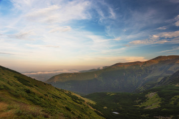 Obraz na płótnie Canvas Evening on a mountain ridge with mystical fogs and scenery in the Ukrainian Carpathians.