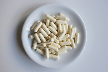 Pills capsules with colostrum, on a white background