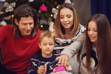 Obraz na płótnie Canvas Beautiful family with presents over Christmas tree