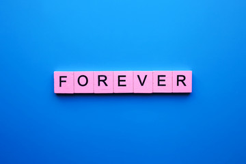 Forever word wooden cubes on a blue background