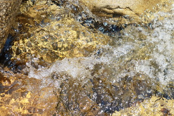 泡立ちうねりながら流れる澄んだ川の水