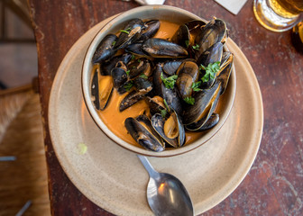 Closeup of traditional dish of French cuisine, appetizing seafood soup with  mussels served in ceramic plate