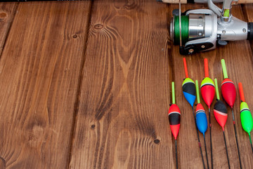 Fishing tackle - fishing rod fishing float and lures on beautiful blue wooden background, copy space