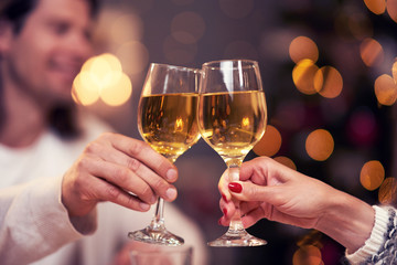 Adult couple toasting wine over Christmas background