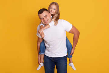 Portrait of happy father and beautiful little girl wering white t shirts and jeans, posing isolated...