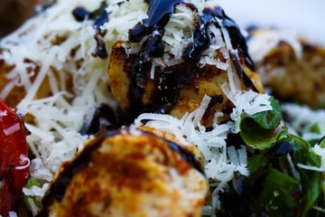 Macro close up of salad with fried turkey breast, tomatoes, green corn lettuce, fresh grated pecorino cheese and brown balsamic creme - Germany