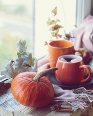 Two cups of coffee, meringues, pumpkins, apples, leaves, plaid on the background of the window, home comfort concept, Thanksgiving, autumn season