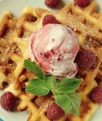 Plate of belgian waffles with ice cream and fresh berries