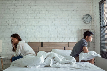 Asian couples quarrel sit in bed ,they argue not to talk to each other. They are unhappy