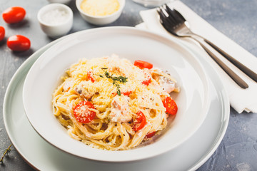 Delicious salmon linguine pasta dish with herbs and grilled salmon filet.