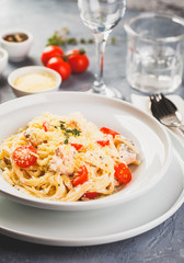 Delicious salmon linguine pasta dish with herbs and grilled salmon filet.