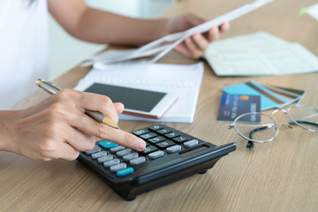 Woman holding bills and using calcutor, account and saving concept.