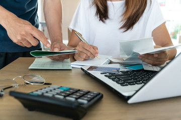Family budget and finances. Young woman doing accounts together with her husband at home,
