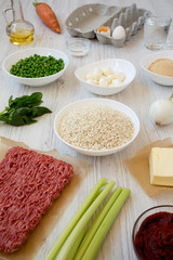 Ingredients for cooking Arancini on a white wooden background, low angle view.