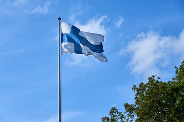 Flag of Finland outdoors against a blue sky.
