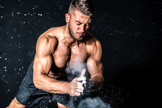 Young muscular man with big sweaty muscles doing push ups workout training with clap his hand above the barbell weight plate on the gym floor with motion blur