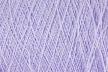 background of lilac acrylic yarn on a cone