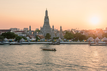 Naklejka premium Wat Arun temple along Chao Phraya River during sunset in Bangkok, Thailand